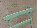a green wooden chair that is on display in a store