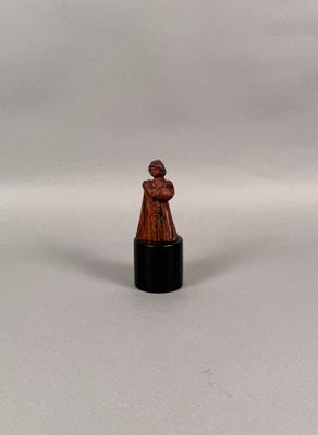 une image représentant une figurine miniature d'une femme sur fond blanc