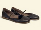 the shoes are black and brown with a blue pom pom on the toe