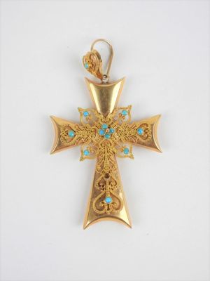 un gros plan d'une croix en or ornée de pierres de turquoise