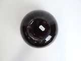 a black vase on a white table with a label on it