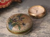 a gold box with a floral design on it