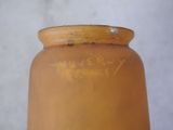 a yellow vase with writing on it sitting on a table