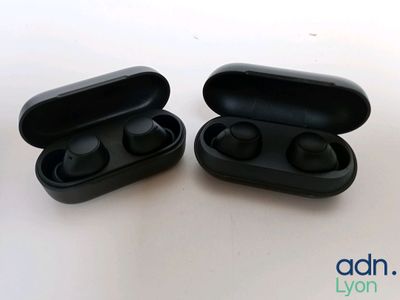 a pair of black earphones sitting on top of a white table