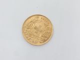 a close up of a gold coin on a white surface