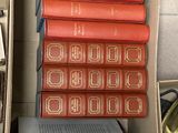 books are stacked in a cardboard box on a table