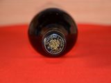 a bottle of wine sitting on a red cloth