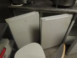 a picture of a kitchen with a white toilet and a skateboard