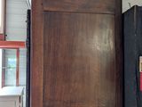a tall wooden cabinet in the middle of a room