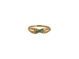 gros plan d'une bague en or avec une pierre verte