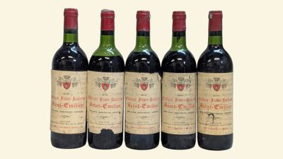 four bottles of wine are lined up on a white surface