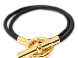 un gros plan d'un bracelet en cuir noir avec un fermoir doré