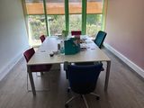 a long table with chairs and a laptop on it in a room