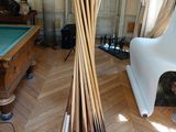 un grand lampadaire en bois au milieu d'une pièce où se trouvent une table de billard et une table de billard