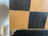 a wooden chess board with black and yellow squares on it