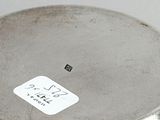 a silver plate that has a sticker on it
