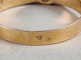 a close up of a gold ring with a diamond on it