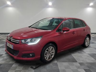 a red citrole parked on a checkered floor in a garage