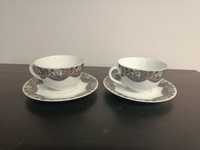 two cups and saucers are sitting on a table