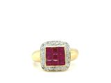 a close up of a red stone and diamond ring on a white background
