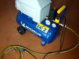 a blue and white air compressor sitting on the floor