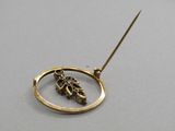 pendentif plaqué or représentant une feuille et une boule au bout d'une tige