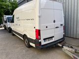 a white van parked in front of a building with a trailer attached to the back of it