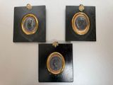 three black and gold medallions mounted on a white wall