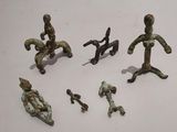 several figurines of different sizes and shapes are displayed next to a ruler