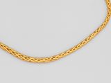 un collier en or avec un motif tressé sur fond blanc