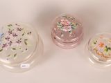 three glass boxes with flowers on them sitting on a white surface