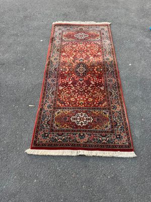 a red rug is laying on the ground next to a blue chair