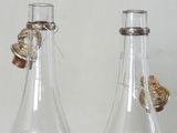 two empty glass bottles with corks on them