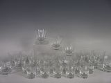 bottles and glasses are lined up on a table with a bottle in the middle