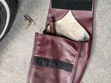 a leather wallet with a knife in it next to a tire