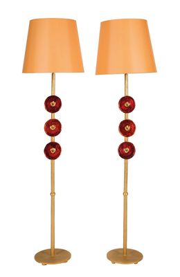 une paire de lampes en verre rouge avec des pieds et des abat-jours dorés