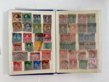 an open book with stamps on it sitting on a white surface