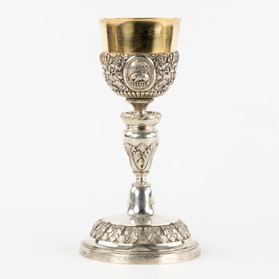 une image représentant une coupe en argent bordée d'or, posée sur une table