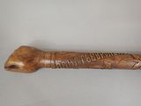 an old wooden walking stick with writing on it sitting on a table