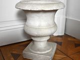 un vase blanc posé par terre dans un coin de la pièce
