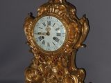 a gold clock that is sitting on a table