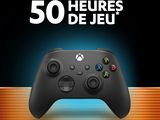 a black xbox game controller sitting on top of a wooden table