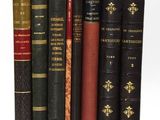plusieurs vieux livres sont alignés sur une surface blanche