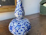 a blue and white vase sitting on a wooden table