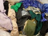 a pile of clothes that is on a bed