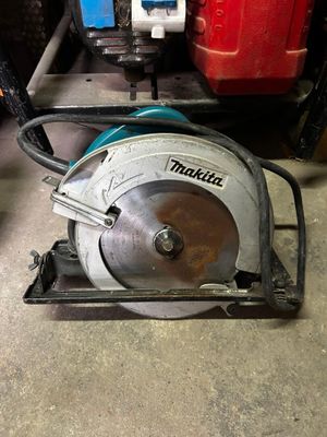 une scie circulaire posée par terre dans un garage