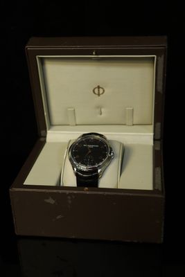 a watch in a box on a black surface