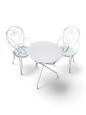 une table blanche et quatre chaises posées sur une surface blanche