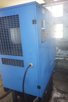 un sécheur d'air industriel installé dans un entrepôt, auquel est raccordé un tuyau