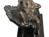 statue of a woman sitting on a chair on a black base